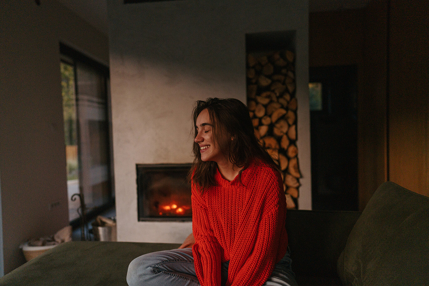 Happy woman by the fire at home